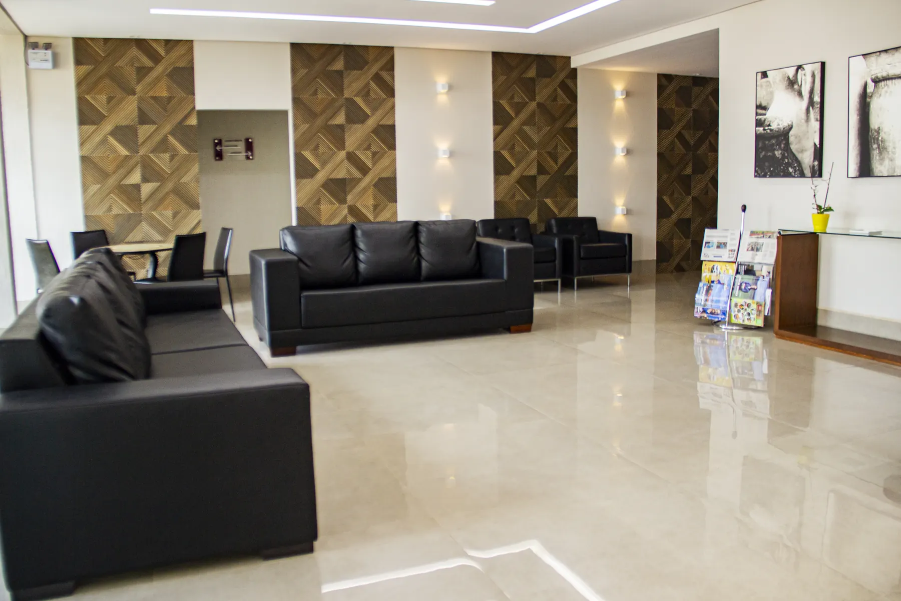 Salão de estar do Paraná Palace Hotel, com sofás pretos e piso de mármore claro